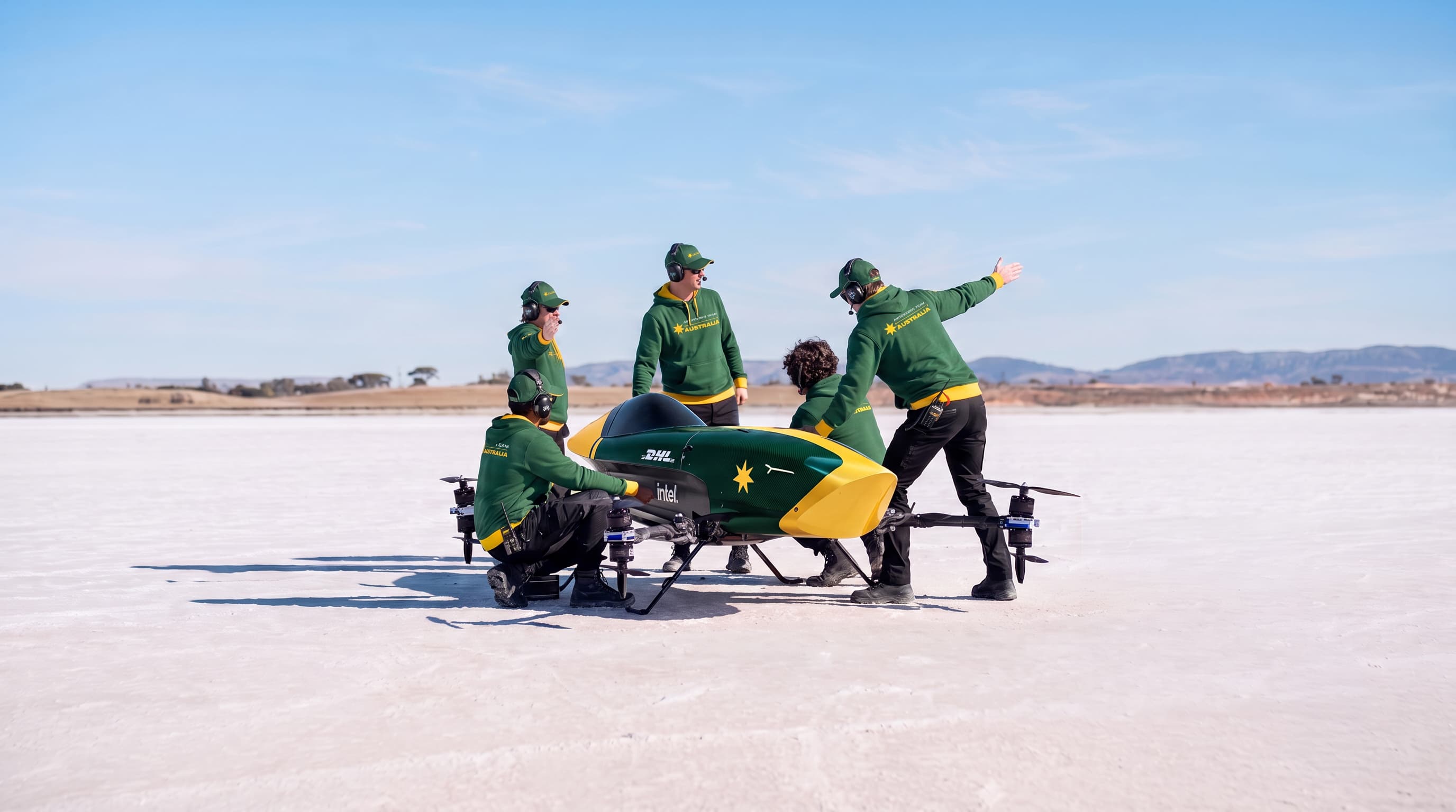 Airspeeder Team Australia crew in green-and-gold with the race craft on the salt flats